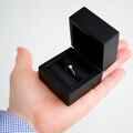 Pudełko czarne na pierścionek na dłoni