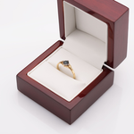 Złoty pierścionek z szafirem w pudełku.